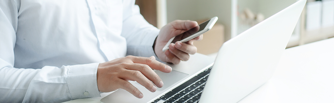 Businessman using smartphone and laptop computer