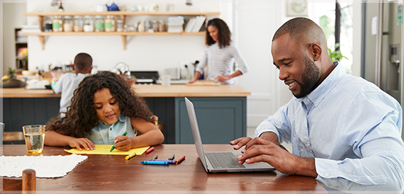 Family at home in the kitchen with laptop computer