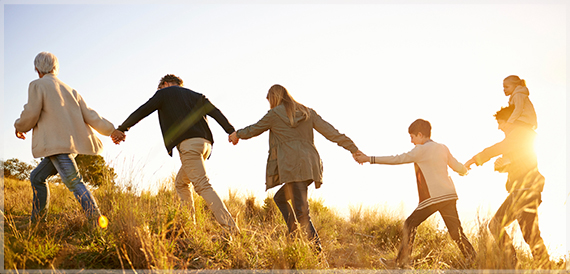 Group of people climbing a hill holding hands